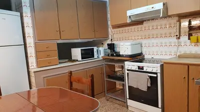 a kitchen with a table and a stove and a microwave at Teal Apartment - Athens Center, 4 BD, 2 BATH in Athens