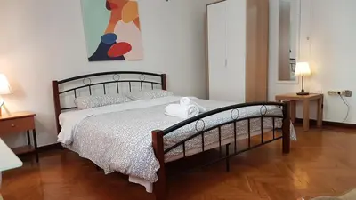 a bedroom with a large bed with a wooden floor at Teal Apartment - Athens Center, 4 BD, 2 BATH in Athens