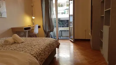 a bedroom with a bed and a view of a balcony at Teal Apartment - Athens Center, 4 BD, 2 BATH in Athens