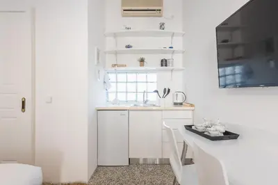 a white kitchen with a sink and a table at Blue Couple House Athens in Athens