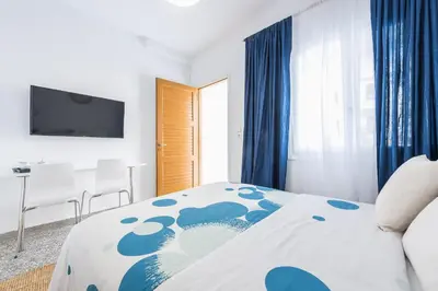 a bedroom with a bed with a blue and white bedspread at Blue Couple House Athens in Athens