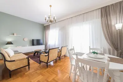 a dining room and living room with a table and chairs at Sophisticated Family House With Acropolis View in Athens
