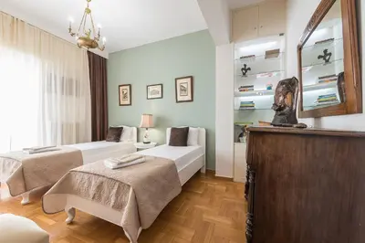a bedroom with two beds and a mirror at Sophisticated Family House With Acropolis View in Athens