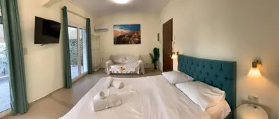 a bedroom with a large bed and a chair at Athens Plaka House in Athens