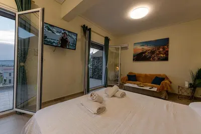 a bedroom with a large white bed with two towels at Athens Plaka House in Athens