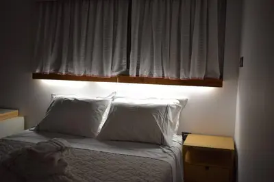 a bedroom with a bed with white pillows and a window at h2h Myrto #Λειτουργικό studio 30' Αθήνα, 15' Αεροδρομιο in Athens