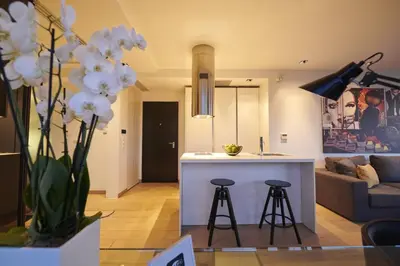 a kitchen and living room with a vase of white flowers at Ma Maison No4,Downtown Loft,360Mbps,Acropolis walk in Athens