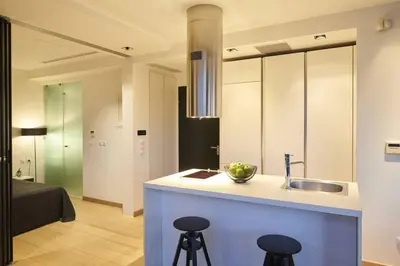 a kitchen with a sink and two bar stools at Ma Maison No4,Downtown Loft,360Mbps,Acropolis walk in Athens