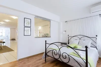 a bedroom with a bed and a dining room at Driopon Apartment - Penthouse in Athens
