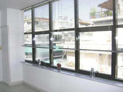 a window in a room with black shutters at Driopon Apartment - Penthouse in Athens