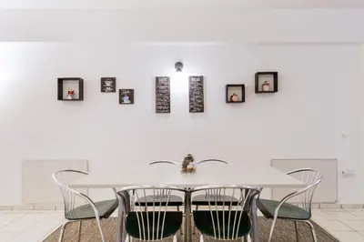 a white dining room with a white table and chairs at Driopon Apartment - Penthouse in Athens