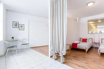 a bedroom with a bed and a desk in a room at Driopon Apartment - Penthouse in Athens