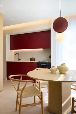 a kitchen with red cabinets and a table and chairs at Sea View Beach Penthouse - Athens Coast in Athens