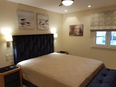 a bedroom with a large bed and two windows at Casa Denva in Kalívia Thorikoú
