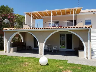 a house with an arched patio with a table at Casa Denva in Kalívia Thorikoú