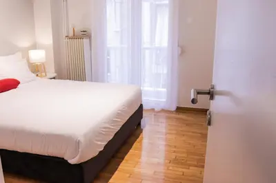 a bedroom with a white bed and a window at Zea Apartments in Piraeus