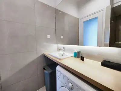 a bathroom with a sink and a mirror at Zea Apartments in Piraeus