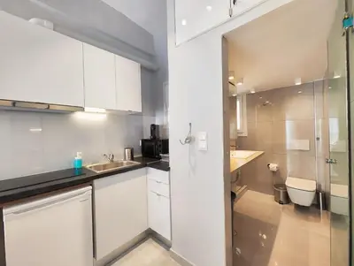 a white kitchen with a sink and a toilet at Zea Apartments in Piraeus