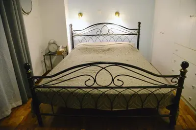 a bed with a metal frame in a room at Freatida apartment in Piraeus