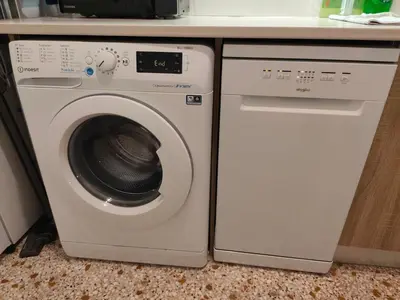 a washer and dryer sitting under a kitchen counter at Freatida apartment in Piraeus