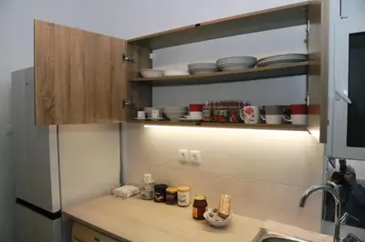 a kitchen with a counter with dishes on the shelves at Freatida apartment in Piraeus