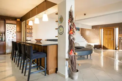 a kitchen and living room with a bar and chairs at Villa Sofia in Anavissos