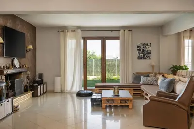 a living room with a couch and a table at Villa Sofia in Anavissos