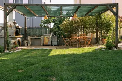 a patio with a table and chairs under a pergola at Villa Sofia in Anavissos
