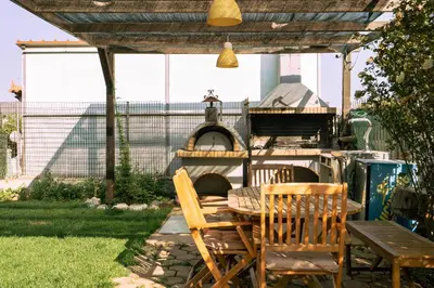 a patio with a table and chairs and an oven at Villa Sofia in Anavissos