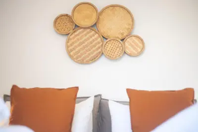 four casserole dishes are hanging on a wall at Urban Boho apartment in Koukaki in Athens