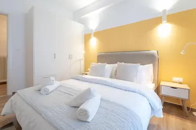 a bedroom with a large white bed with towels on it at Urban Boho apartment in Koukaki in Athens