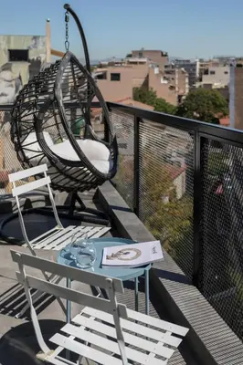 a swinging chair and a table on a balcony at Melo Athens in Athens