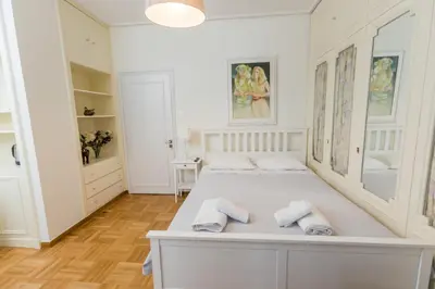 a bedroom with a white bed with towels on it at Filoxenia MG Kolonaki Athens in Athens