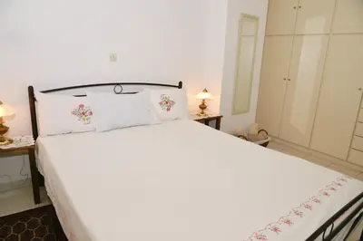 a bedroom with a large white bed with pillows at TRADITIONAL HOUSE in Athens