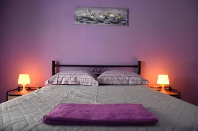 a purple bedroom with a large bed with two lamps at Colourful Apartment in AthensCity 1min from Subway in Athens