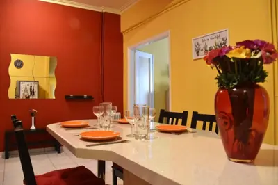 a table with a vase of flowers on top of it at Colourful Apartment in AthensCity 1min from Subway in Athens