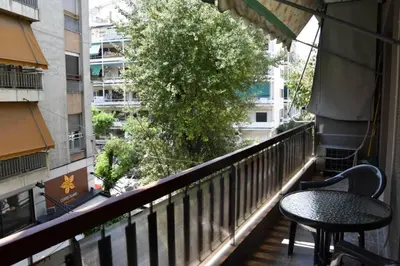 a balcony with a table and chair on a balcony at Colourful Apartment in AthensCity 1min from Subway in Athens