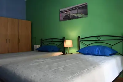 a green bedroom with two beds with blue pillows at Colourful Apartment in AthensCity 1min from Subway in Athens