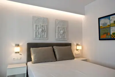 a bedroom with a bed with two night stands and two lamps at SYNATHENS APARTMENTS & STUDIOS in Athens