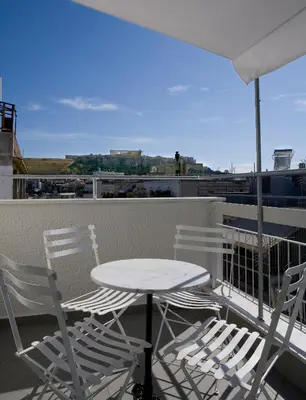 a table and chairs on a balcony with a view at SYNATHENS APARTMENTS & STUDIOS in Athens