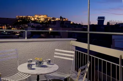 a table and chairs on a balcony with a view at SYNATHENS APARTMENTS & STUDIOS in Athens