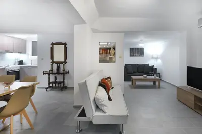 a living room with a couch and a table at 2 bedroom aprtmnt next to Hilton and all hospitals in Athens
