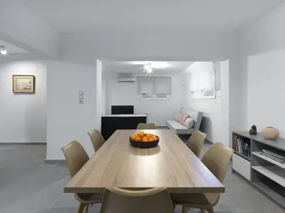 a living room with a wooden table and chairs at 2 bedroom aprtmnt next to Hilton and all hospitals in Athens