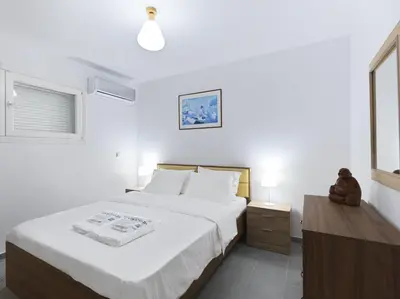 a bedroom with a large white bed and a window at 2 bedroom aprtmnt next to Hilton and all hospitals in Athens