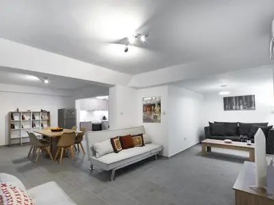 a living room with a couch and a table at 2 bedroom aprtmnt next to Hilton and all hospitals in Athens