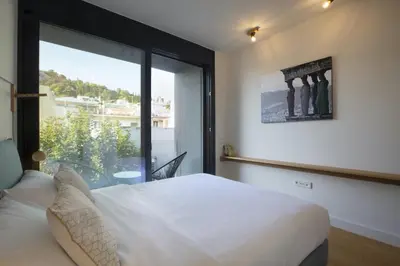 a bedroom with a bed and a large window at Luxury Acropolis Rooftop Apartment in Athens