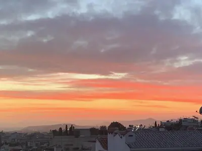 a sunset view of a city with buildings at Luxury Acropolis Rooftop Apartment in Athens