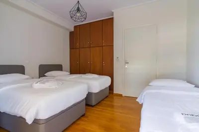 three beds in a room with wooden cabinets at Two Bedroom Apartment in Chalandri with Balcony in Athens