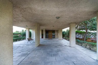 a building with columns and a bench in a courtyard at Two Bedroom Apartment in Chalandri with Balcony in Athens