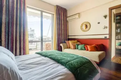 a bedroom with two beds and a large window at Elena's Athenian Penthouse in Athens